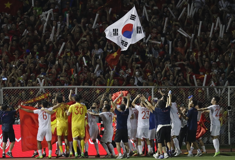 ▲ 베트남 22세 이하(U-22) 축구 대표팀이 10일 필리핀 마닐라 리잘 메모리얼 스타디움에서 열린 ‘2019 동남아시안(SEA) 게임’ 축구 결승전에서 인도네시아를 3-0으로 물리치고 우승을 확정 지은 뒤, 금성홍기와 태극기를 흔들며 응원을 펼친 관중들에게 감사 인사를 하고 있다.