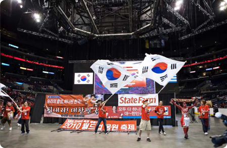 한국의 월드컵 승리를 응원하기 위해 모인 사람들이 커다란 태극기를 흔들고 있다.