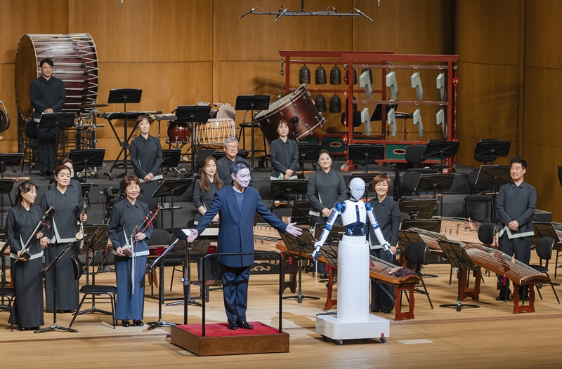 ▲ 지난달 30일 서울 중구 국립극장 해오름극장에서 열린 국립국악관현악단의 공연 ‘부재’에서 최수열 지휘자가 로봇 지휘자 ‘에버(EveR) 6’의 팔 동작을 따라 하며 함께 인사하고 있다. 국립극장