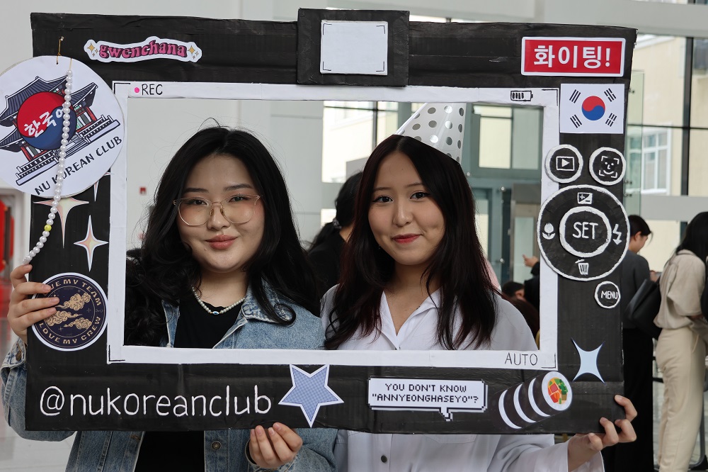 Korean Club에서 제작한 사진 프레임을 들고 포즈를 취하는 참가자들